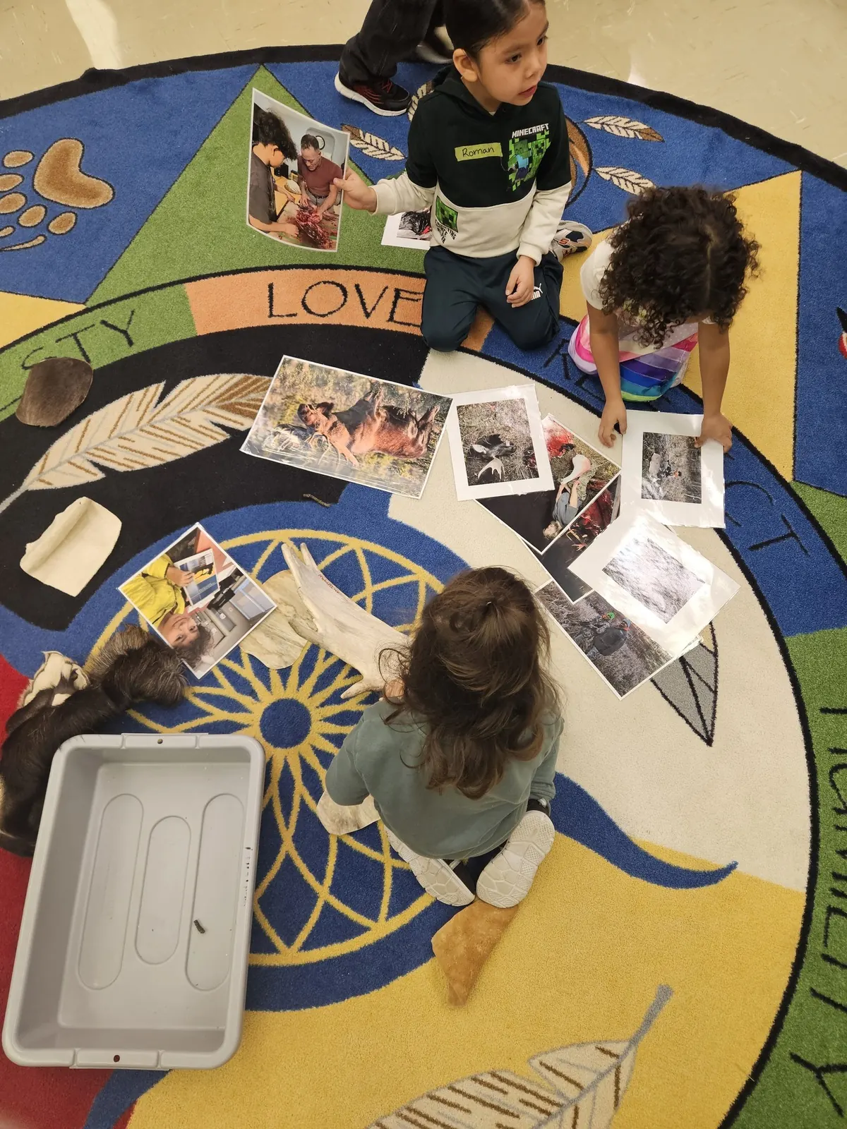 A child laying photographs out on the medicine wheel rug.
